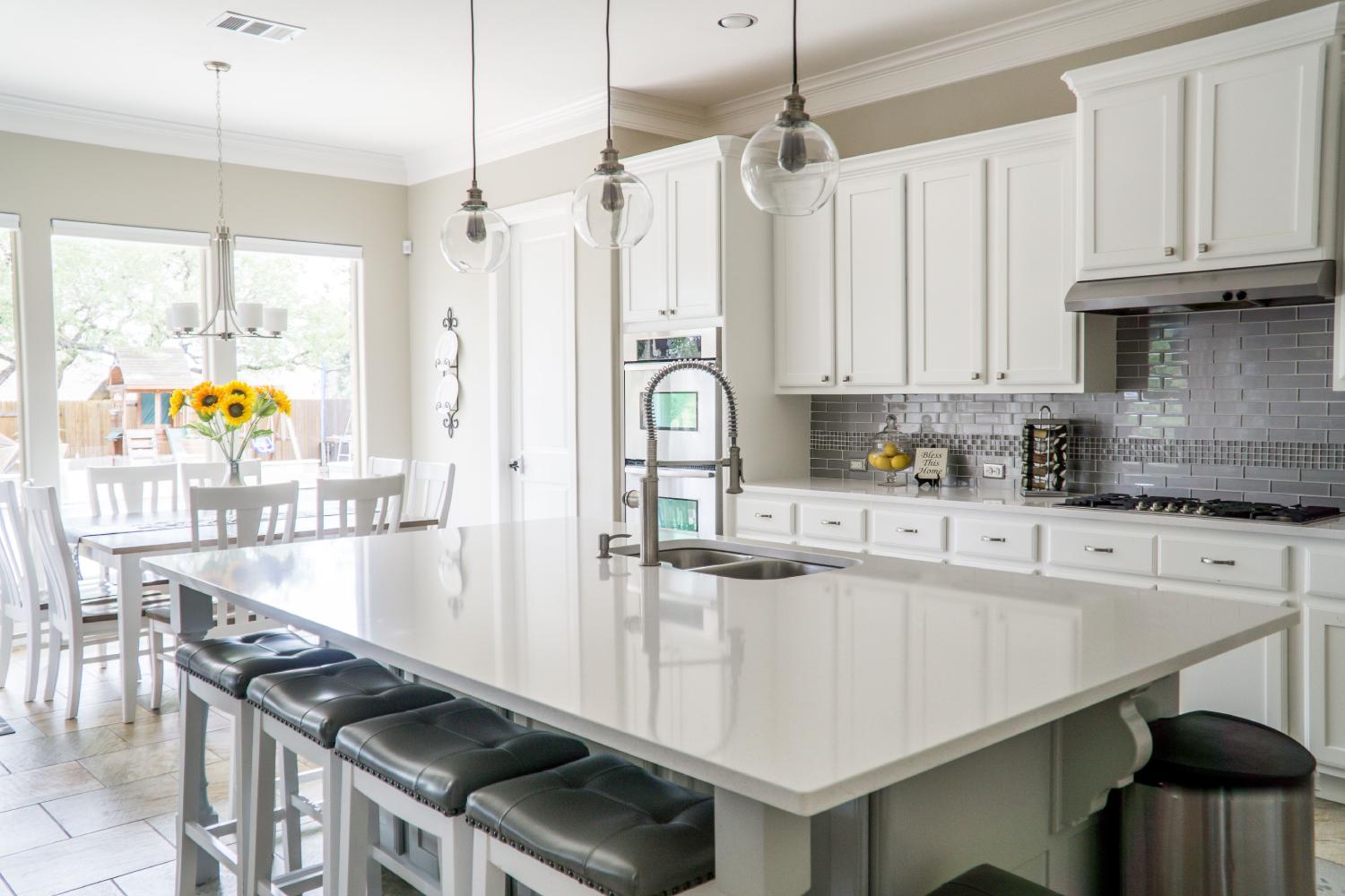 a white kitchen island with four chairs